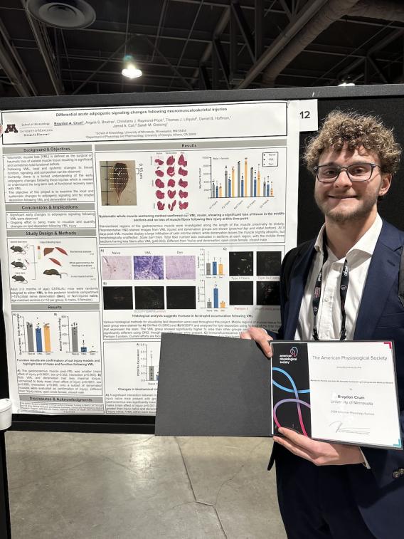 Crum in front of poster holding award