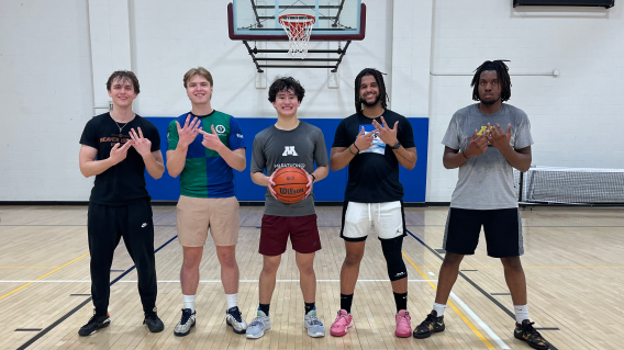 Group picture of 5 boys under a basketball hoop