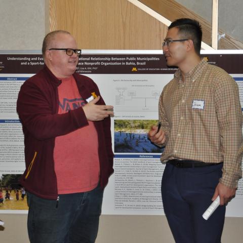 Two graduate students discussing near research poster